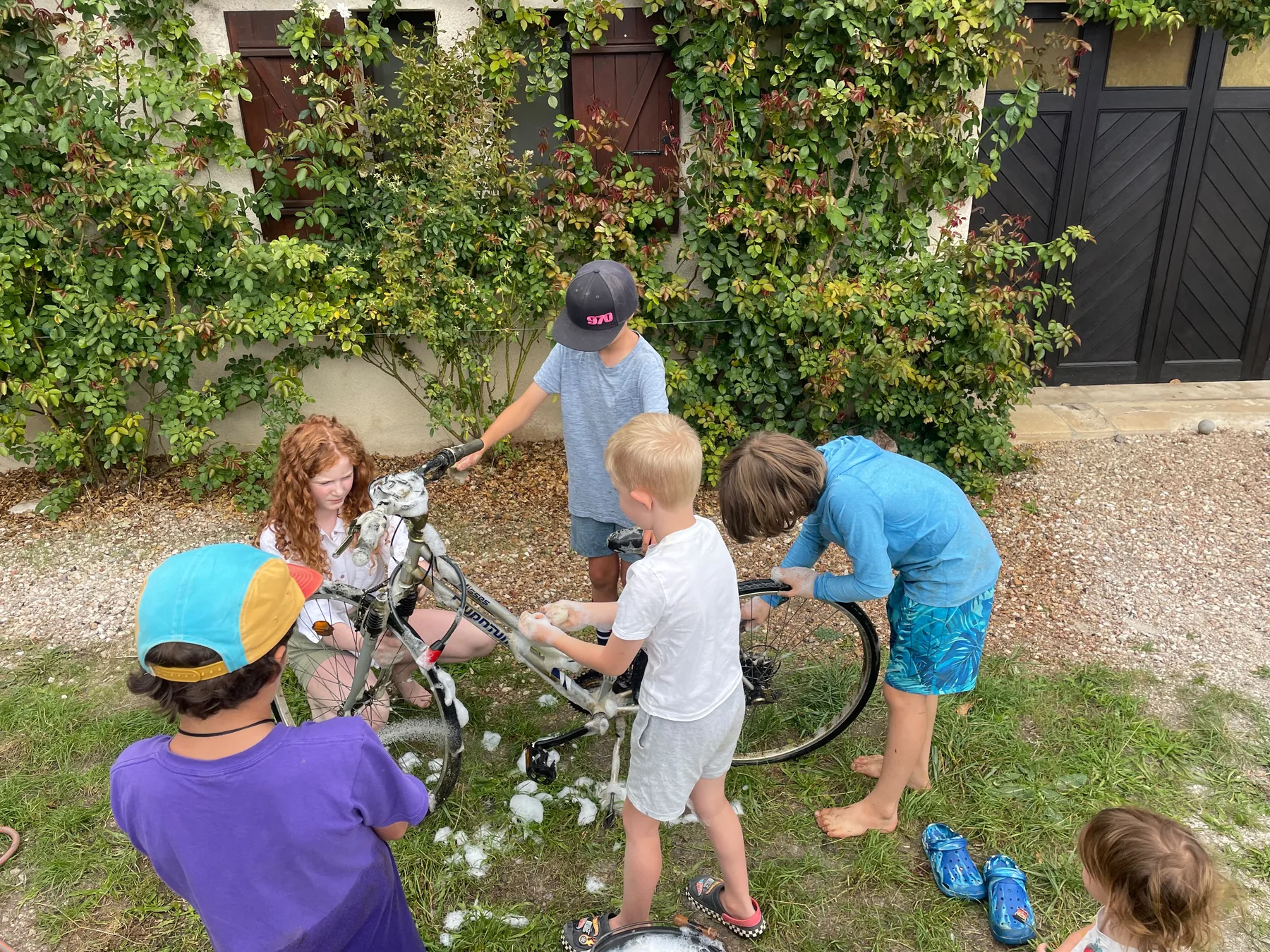 Soap, sponges and a group of friends giving a bicycle a good clean.