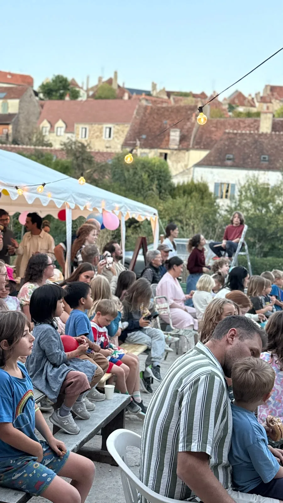 Families filling the courtyard for another gathering under the string lights.
